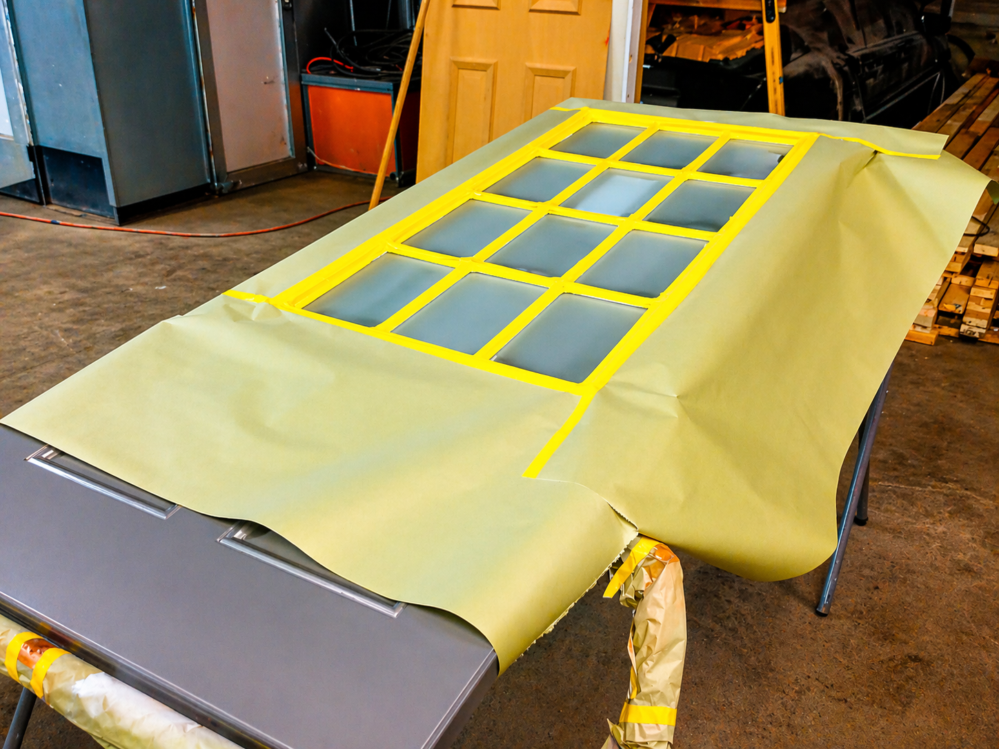 Garage door masked with yellow tape windows to create tinted glass illusion