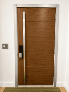 Stylish wooden security door with metal frame and electronic lock system.